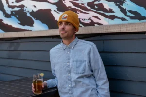 Man Drinking Beer Wearing Custom Richardson Beanie With Sublimated Patch Decoration