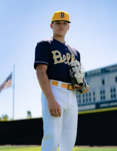 Baseball player holding mitt wearing Richardson baseball hat and uniform