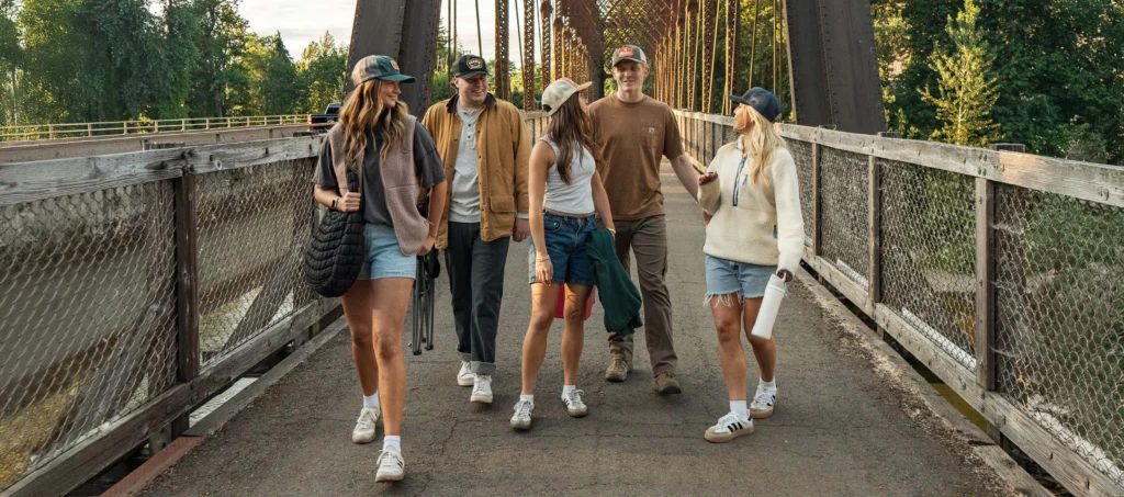Group of friends walking over bridge wearing custom Richardson hats
