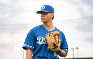 Baseball player holding mitt wearing Richardson baseball hat and uniform